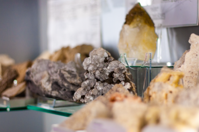 Mettinger Mineralmuseum Auf einem gläsernen Tisch sind verschiedene schöne funkelnde Mineralien zu sehen.