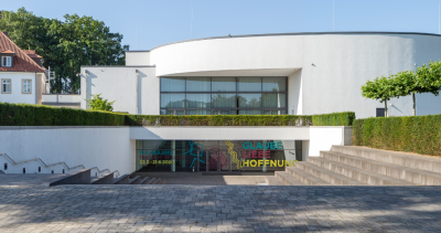 Dreiflessen Collection Außenansicht des Dreiflessen Gebäudes. Treppen führen hinab zum Eingang.