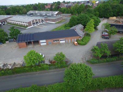 Außenansicht aus der Vogelperspektive auf den Bauhof Mettingen. Ein langezogenes Klinkergebäude mit Garagend und dunklem Dach.